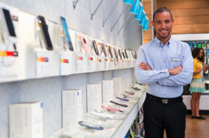 Man Standing Next to Wall of Cellphones