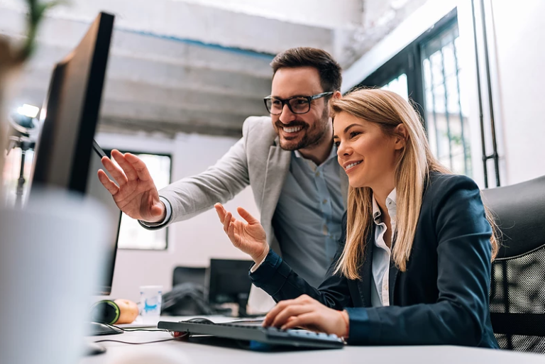 Coworkers Looking and Smiling at Computer Screen