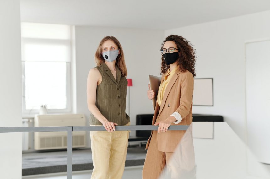 two women in masks checking in at front desk